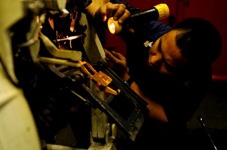 US Navy 120124-N-UT411-050 Aviation Ordnanceman 1st Class Alexander Cesar, assigned inspects an M61-A1 Gatling gun in aboard Nimitz-class aircraft