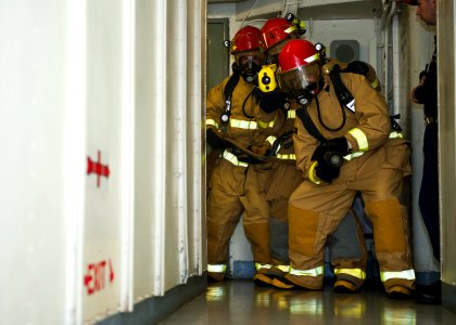 US Navy 120123-N-FI736-090 Sailors advance down a passageway during a general quarters training exercise aboard the aircraft carrier USS Enterprise