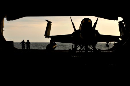 US Navy 120121-N-ZI635-067 Sailors watch the sunset from the hangar bay aboard the Nimitz-class aircraft carrier USS Carl Vinson (CVN 70)