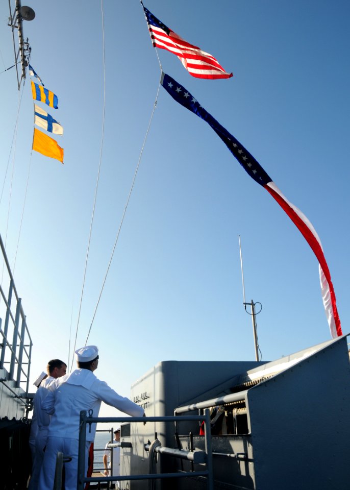 US Navy 120123-N-BK435-007 Sailors assigned to the submarine tender USS Frank Cable (AS 40) raise the Ensign and the 165-foot Homeward Bound Pennan