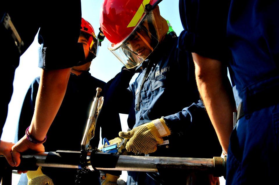 US Navy 120124-N-ZI635-484 Damage Controlman Fireman Christopher A. Johnson practices pipe patching during a firefighting drill aboard the Nimitz-c
