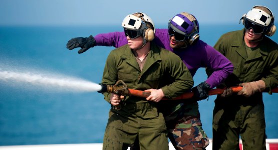US Navy 120126-N-PB383-178 Aviation Boatswain's Mate (Fuels) Airman Edwin Montanez directs a Marine nozzleman during a firefighting drill on the fl