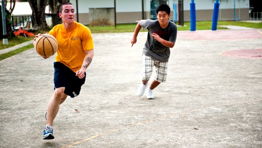 US Navy 120127-N-OY799-107 A Sailor assigned to the Nimitz-class aircraft carrier USS John C. Stennis (CVN 74) plays basketball with boys and staff
