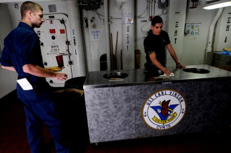 US Navy 120124-N-RG587-209 Aviation Ordnanceman Airman Dominic Yanoz cleans while ensuring Sailors properly separate their trash in the scullery li