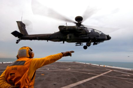 US Navy 120127-N-PB383-001 A Sailor guides a helicopter off the flight deck