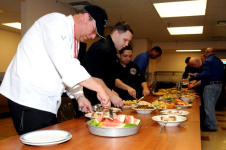 US Navy 120127-N-GU530-123 dam Weiner, left, helps Sailors serve specially prepared dishes during lunch at Naval Submarine Support Center Bangor