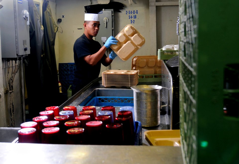 US Navy 120124-N-RG587-210 Airman Eric Jimenez cleans trays in the scullery aboard the Nimitz-class aircraft carrier USS Carl Vinson (CVN 70)