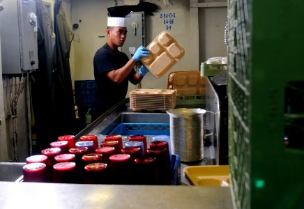 US Navy 120124-N-RG587-210 Airman Eric Jimenez cleans trays in the scullery aboard the Nimitz-class aircraft carrier USS Carl Vinson (CVN 70)