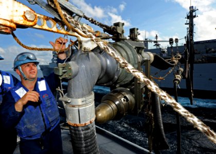 US Navy 120124-N-VH839-015 Boatswain's Mate Seaman Jesse Permenter secures a fueling hose to a hose assembly aboard the Arleigh Burke-class guided