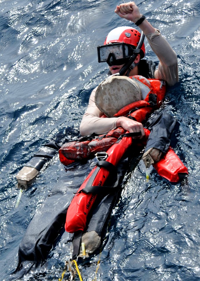 US Navy 120124-N-ZF681-155 Search and rescue swimmer Ensign Gregory Reichel, assigned to the guided-missile destroyer USS Halsey (DDG 97), signals