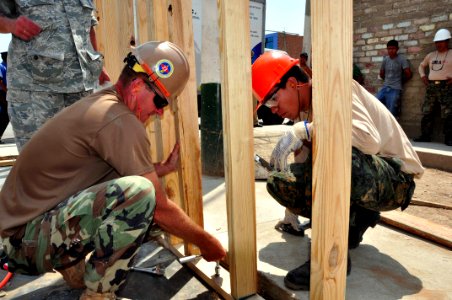 US Navy 120127-A-TF780-223 Utilitiesman 1st Class, Bruce Nisbet and a Navy combat engineer from the Peruvian Infanteria De Marina tighten a screw o