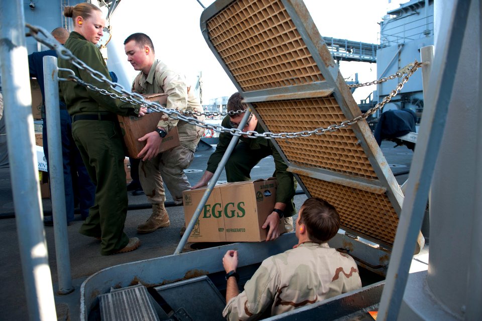 US Navy 120129-N-KS651-226 Sailors aboard the amphibious dock landing ship USS Pearl Harbor (LSD 52) move supplies during a replenishment at sea
