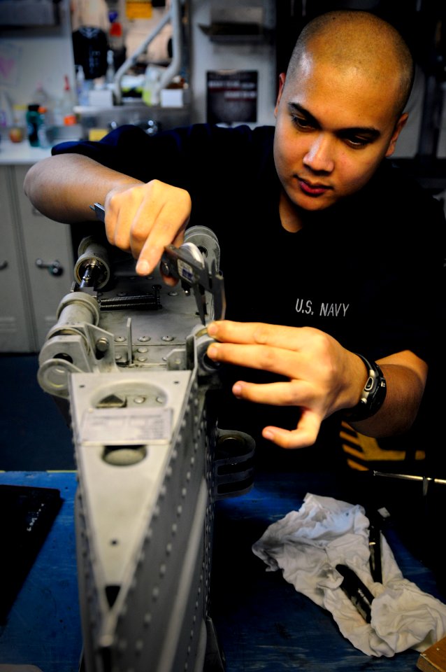 US Navy 120125-N-MD252-056 Aviation Structural Mechanic Airman Roy Madrid uses a micrometer to measure part of a center stabilator for an SH-60 Sea