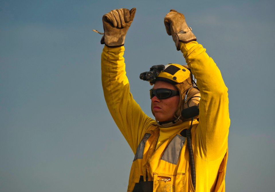 US Navy 120127-N-PB383-874 A Sailor guides a helicopter off the flight deck