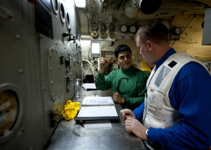 US Navy 120130-N-DR144-692 A Sailor discusses catapult operations with Rear Adm. Thomas K. Shannon, commander of Carrier Strike Group (CSG) 1, in t