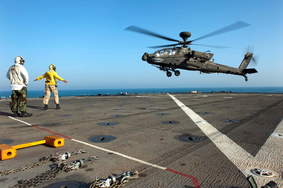 US Navy 120128-N-KS651-244 A Sailor signals a helicopter to land on the flight deck of USS Pearl Harbor