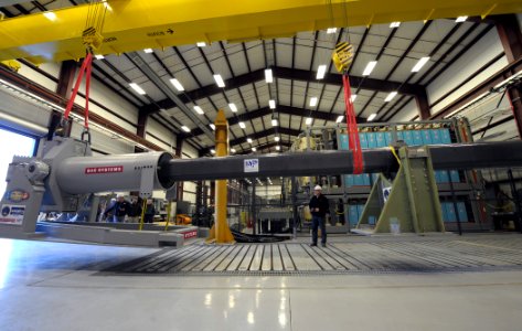 US Navy 120130-N-PO203-069 A government worker uses a crane to maneuver a 32-MJ version of the Office of Naval Research-funded Electromagnetic Rail