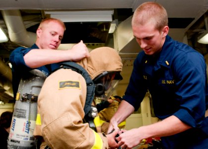 US Navy 120126-N-ZZ999-003 Sailors dress out in a full firefighting ensemble as part of damage control Olympics aboard the guided missile destroyer