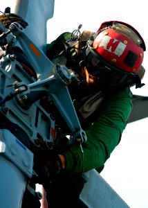 US Navy 120201-N-BT887-127 Aviation Structural Mechanic 3rd Class Makos Chhay performs a turnaround inspection on an MH-60R Sea Hawk helicopter fro