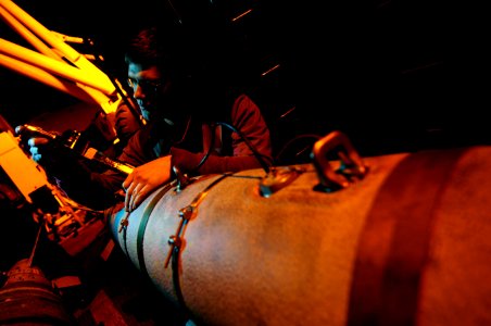 US Navy 120127-N-MD252-588 Aviation Ordnanceman Airman James Lewis inspects ordnance on the flight deck aboard the The Nimitz-class aircraft carrie