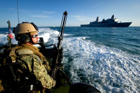 US Navy 120201-N-PC102-184 A Sailor mans a .50-caliber machine gun while conducting security escort operations for ships transiting out to sea thro