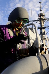 US Navy 120128-N-OH194-066 Gas Turbine Systems Technician (Mechanical) Fireman Colin Combs collects a fuel sample during an underway replenishment