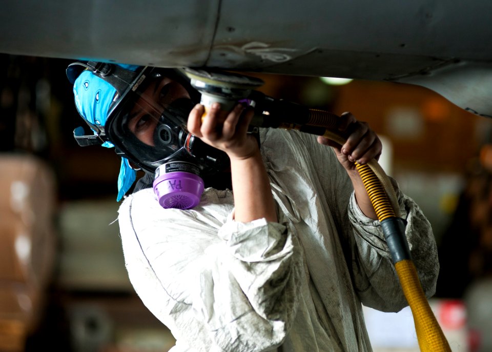 US Navy 120201-N-BT887-161 Aviation Structural Mechanic Airman Holly Harris sands the fuselage of an F-A-18E Super Hornet from the Tophatters of St