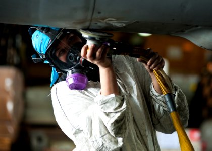 US Navy 120201-N-BT887-161 Aviation Structural Mechanic Airman Holly Harris sands the fuselage of an F-A-18E Super Hornet from the Tophatters of St