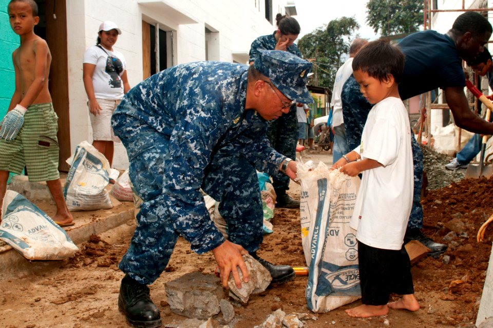 US Navy 120201-N-OH194-042 Senior Chief Electrician's Mate Crisanto Flores removes construction debris during a community service project in the vi