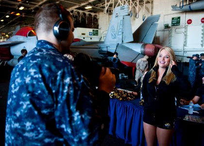 US Navy 120131-N-FI736-056 Mass Communication Specialist 2nd Class Nathan Carpenter interviews a Jacksonville Jaguar cheerleader in the hangar bay