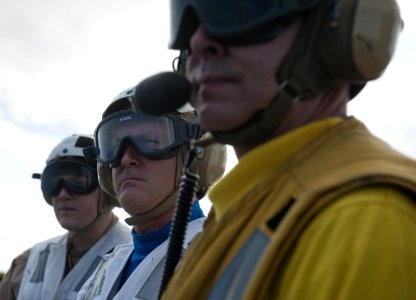US Navy 120130-N-DR144-620 Rear Adm. Thomas K. Shannon, center, commander of Carrier Strike Group (CSG) 1, observes flight operations
