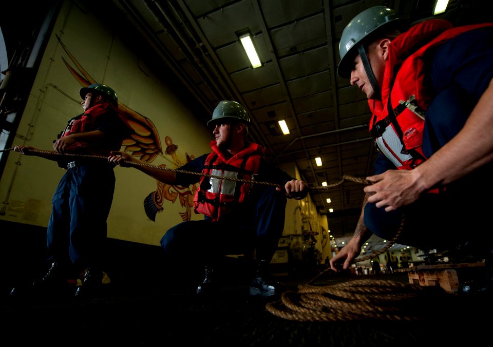 US Navy 120202-N-DR144-123 Line handlers take in a line in the hangar bay aboard the Nimitz-class aircraft carrier USS Carl Vinson (CVN 70) as the