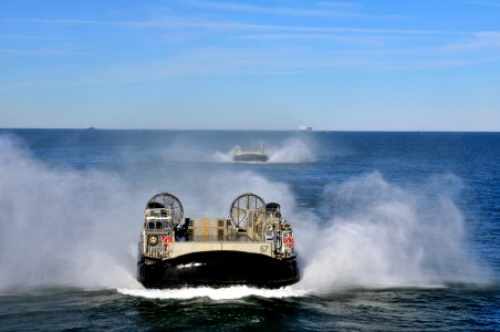 US Navy 120130-N-ZZ999-091 A group of landing craft air cushions (LCACs) from Assault Craft Unit (ACU) 4 approach the amphibious assault ship USS W