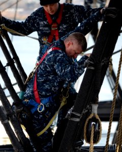 US Navy 120131-N-SH953-105 Seaman William Gillaspie assists Master Chief Petty Officer of the Navy (MCPON) Rick D. West as he climbs down the main
