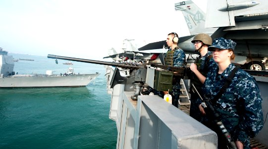 US Navy 120130-N-OY799-066 Sailors stand watch on a .50-caliber machine gun on the flight deck of the Nimitz-class aircraft carrier USS John C. Ste