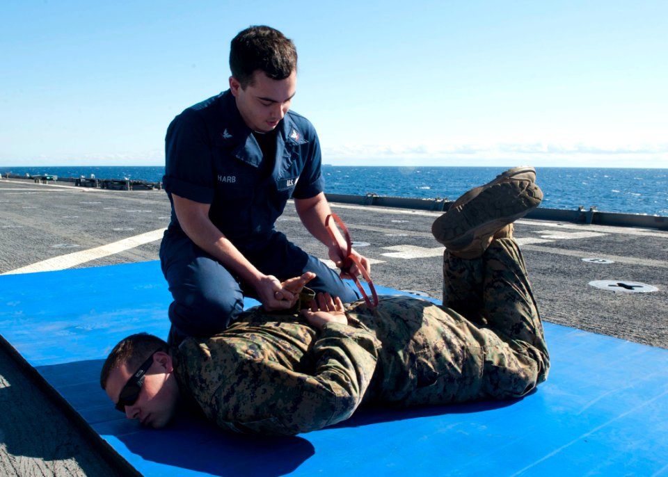 US Navy 120201-N-NR955-057 Logistics Specialist 3rd Class Anthony W. Harb cuffs Lance Cpl. Karl J. Leitz, a military policeman assigned to Combat L