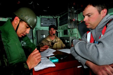 US Navy 120202-N-IZ292-079 Royal Moroccan Navy 1st Sgt. Hamid Karada checks the identification papers of Chief Gunner's Mate Sean Holmes, simulatin