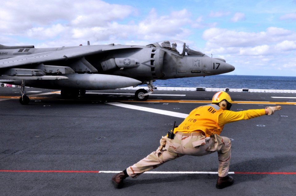 US Navy 120204-N-UM734-145 A Sailor directs the launch of a Harrier jet