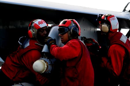 US Navy 120204-N-ZI635-486 Sailors unload ordnance from an F-A-18C Hornet aboard the Nimitz-class aircraft carrier USS Carl Vinson (CVN 70)