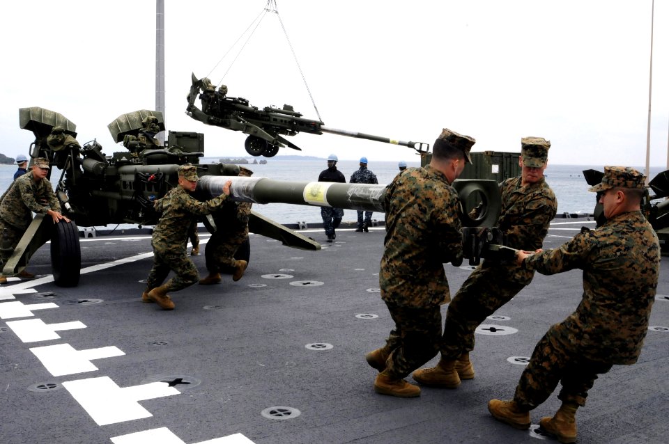 US Navy 120202-N-WV964-161 Marines assigned to the 31st Marine Expeditionary Unit (31st MEU) haul a 155 mm Howitzer onto the flight deck of the for