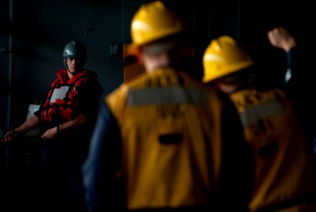 US Navy 120202-N-DR144-198 Boatswain's Mate Seaman Payne Ivie listens to commands from rig captains while manning a line in the hangar bay aboard t