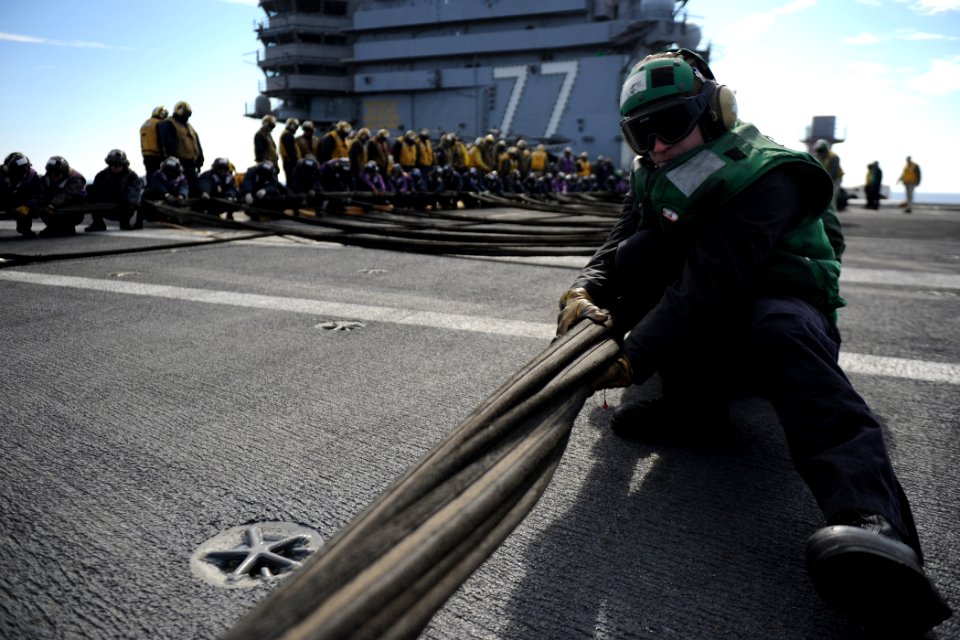 US Navy 120204-N-XE109-127 Aviation Boatswain's Mate (Equipment) 2nd Class Zachary J. Everett pulls an aircraft barricade during a drill on the fli