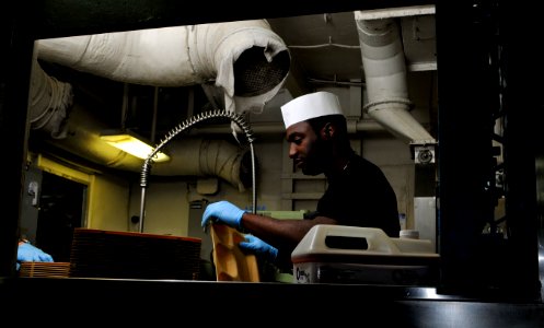 US Navy 120206-N-ZI635-031 Aviation Electrician's Mate Airman Michael Johnson, assigned to Strike Fighter Squadron (VFA) 81, washes dishes in the s