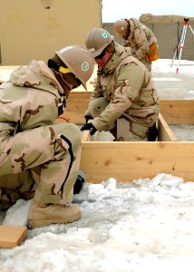 US Navy 120202-N-SD610-005 eabees assigned to Lagman Detachment of Naval Mobile Construction Battalion (NMCB) 7 construct wooden flooring to be ins