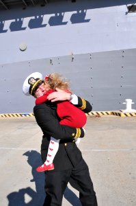 US Navy 120207-N-QY430-085 Lt. Cmdr. Julian Carswell hugs his daughter during a homecoming celebration for the amphibious assault ship USS Bataan
