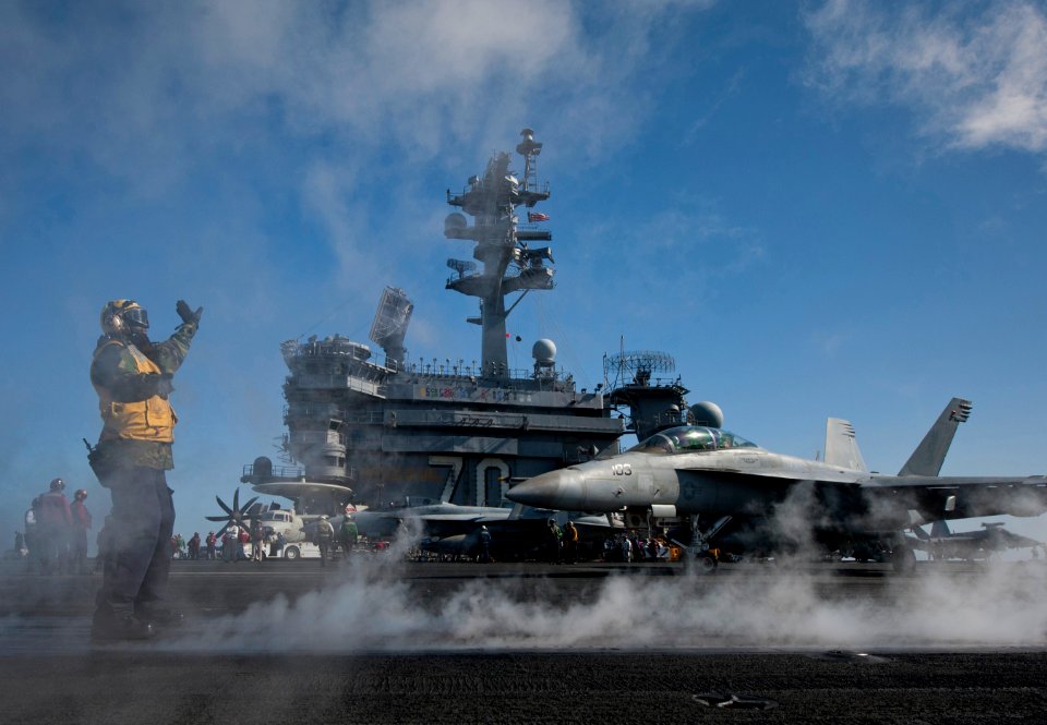 US Navy 120206-N-DR144-651 Aviation Boatswain's Mate (Handling) Emmanuel Gedeon directs aircraft onto the waist catapults