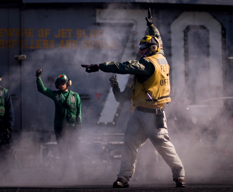 US Navy 120206-N-TZ605-356 Lt. Paul Dussault, a flight deck officer aboard the Nimitz-class aircraft carrier USS Carl Vinson (CVN 70), performs a f