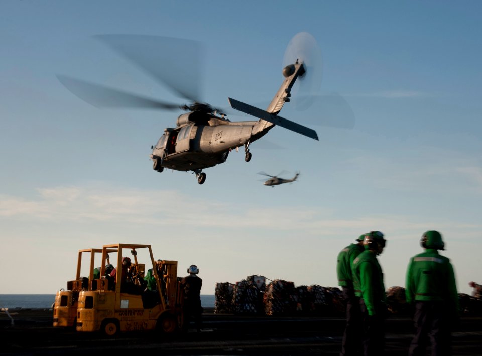 US Navy 120209-N-DR144-361 MH-60S Sea Hawk helicopters assigned to Helicopter Anti-Submarine Squadron (HSC) 23 deliver supplies to the flight deck