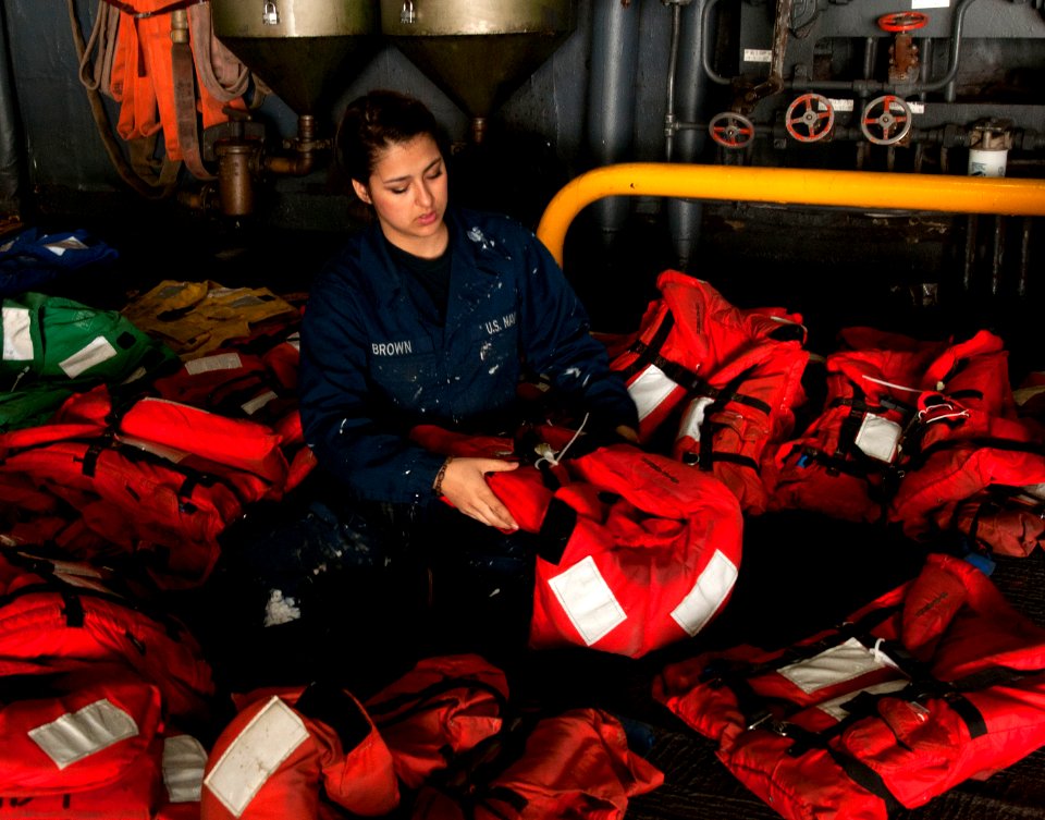 US Navy 120208-N-NL541-175 Seaman Jacqueline Brown, from New York, inspects float coats and life jackets in the hangar bay of the amphibious assaul