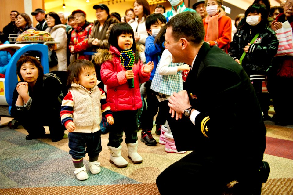 US Navy 120207-N-CZ945-102 Lt. j.g. Geordie Kelly, fleet band master of U.S. 7th Fleet Band, shows children how to use a maraca shaker during a per